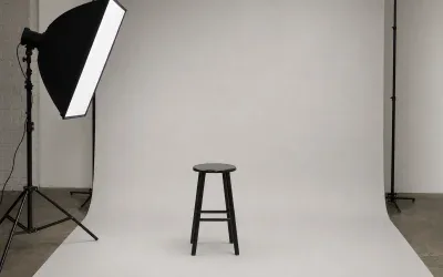 Studio fotograficzne z jasnym tłem, stołkiem i lampą do zdjęć dokumentowych